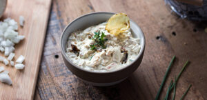 Bowl of caramelized onion dip with potato chip