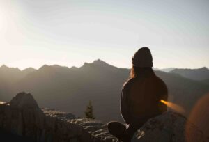 Person sitting overlooking mountains 