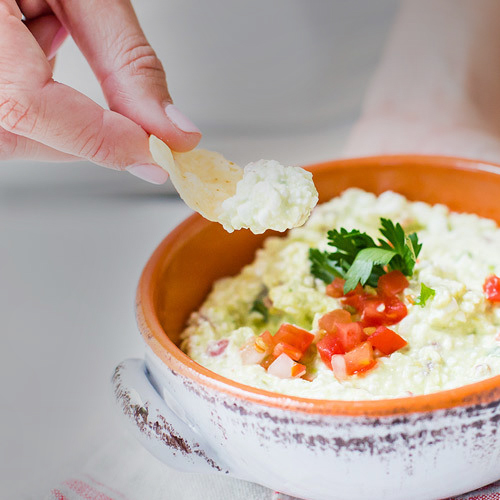 dipping a chip into cottage cheese salsa