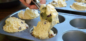 Muffin mix being added to muffin tin